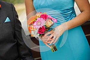 Bridesmaid and groomsman walking down the aisle with colorful bo photo