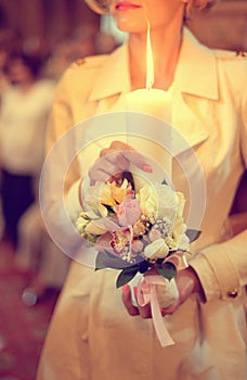 Bridesmaid holding candle with flowers