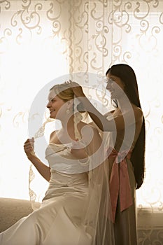 Bridesmaid placing veil.