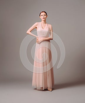 Bridesmaid`s dresses. Elegant moscato dress. Beautiful pink chiffon evening gown. Studio portrait of young brunette woman.