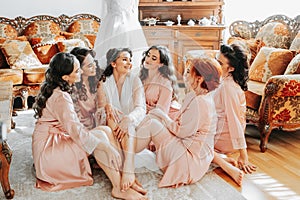 The bridesmaids look at the smiling bride. The bride and her fun friends are celebrating a bachelorette party