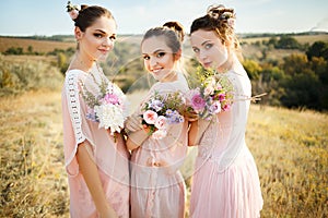 Bridesmaids in pink dresses with bouquets