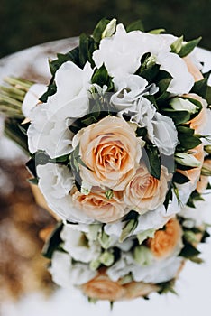The brideâ€™s wedding bouquet lies on a glass table