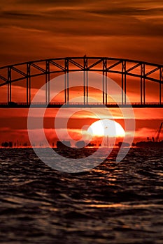 Bridge arch silhouette in front of large setting sun