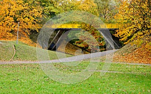 Bridge in the autumn park with colorful foliage on the trees