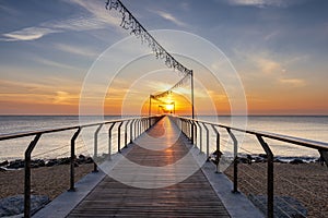 Bridge on the beach at sunrise