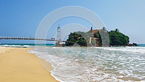 Bridge from the beach to the island in the ocean