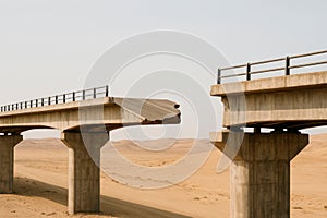 A bridge that breaks off in the middle of the desert.