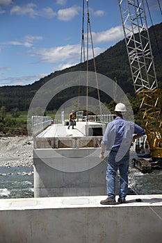 Bridge builders swing in another beam