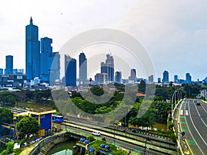 A bridge with cars traverses a river in Kuningan, Jakarta, Indonesia.