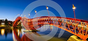 A bridge in the city at night. The bridge against the sky during the blue hour. Architecture and design. The Python Bridge, Amster