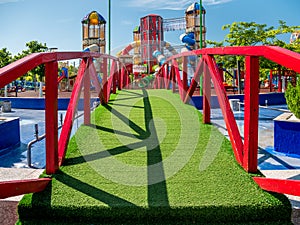 Bridge covered with artificial grass leading to a children`s playground, in Children`s World Park, Bucharest