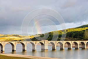 Bridge, Ebro river, rain clouds, rainbow. Horna de Ebro, Cantabria, Spain