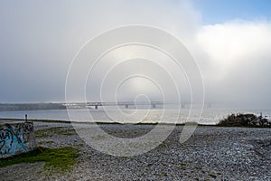 A bridge in fog. Blue ocean and mist in the background. Picture from the bridge connecting Sweden with Denmark