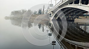 Bridge in the fog. River landscape. Street lights.