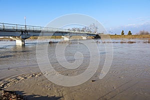 Bridge with full river . River is full . Bridge to cross the river that is flooding.