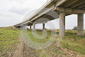 Countryside road passing under a highway bridge