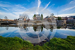 Bridge and houses reflection in Carroll Creek, in Frederick, Mar