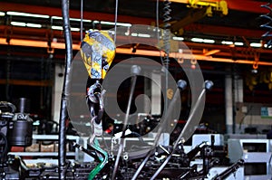 Bridge lifting Crane Hook against the background of the Assembly Line industrial factory.