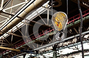 Bridge lifting Crane Hook against the background of the Assembly Line industrial factory.