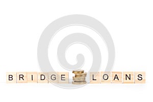 Bridge loans- word composed fromwooden blocks letters on White background, copy space for ad text. photo