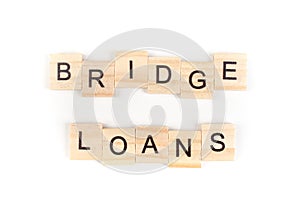 Bridge loans- word composed fromwooden blocks letters on White background, copy space for ad text