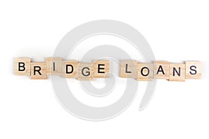 Bridge loans- word composed fromwooden blocks letters on White background, copy space for ad text photo