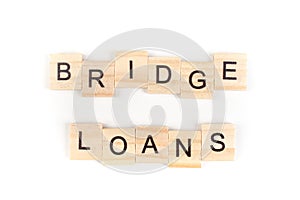 Bridge loans- word composed fromwooden blocks letters on White background, copy space for ad text photo