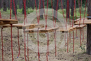 Bridge made of logs tied to ropes, part of the rope course. Rope park in the forest. A route for training courage