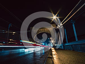 bridge at night with vehicles light trails