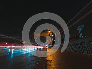 bridge at night with vehicles light trails