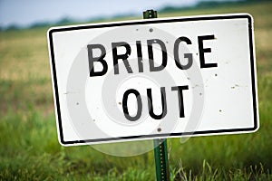 Bridge Out Sign With Bullet Holes and Green Pasture