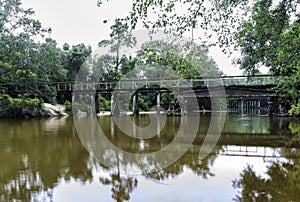 A bridge over the Bogue Falaya River in a forest with a landing