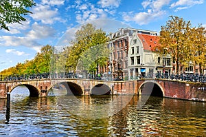 Bridge over channel in Amsterdam Netherlands houses river Amstel landmark old european city spring landscape.