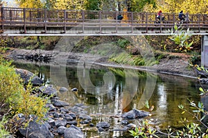 Bridge over colored water. Autumn reflections on the Wenatchee River. Covered by a foot bridge and a girl with bright red hair