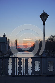 Bridge over isar river munich, with old lantern, at sunset