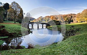 Bridge over main lake in Stourhead Gardens during Autumn.
