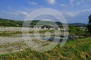 Bridge over the mountains river Torrente Parma in summer across green hills. Langhirano, Emilia-Romagna, Italy