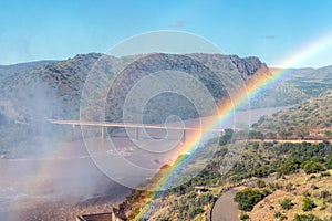 Bridge over Orange River below Gariep Dam behind double rainbow