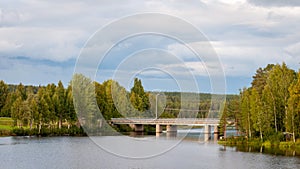 Bridge over the pond. A fabulous landscape of a Finnish lake in the midst of a dense Scandinavian green forest. The concept of