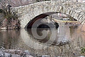 Bridge over pond with reflection in the water on a sunny winter day