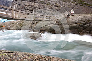 Bridge over rapid runoff water from glacier photo