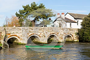 Bridge over River Avon Christchurch Dorset England UK with green boat