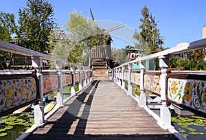 The bridge over the river with a beautiful railing that leads to the old windmill