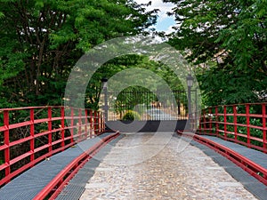 Bridge over the river henares with red pads and stone floor for entrance to a farm with an iron gate closing it