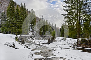 Bridge over the river in the mountains in winter, snow landscape