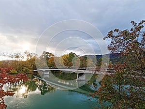 Bridge over river sorounded by autumn colored trees