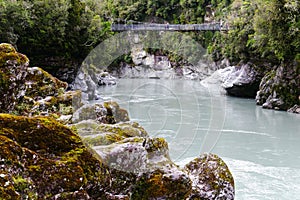 Bridge over the river surrounded by lush greenery. Hokitika gorge, New Zealand.