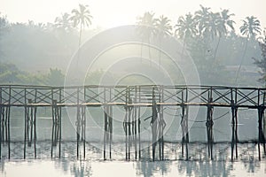 Bridge over river. Tropical landscape. Morning fog. Beautiful scenery with a bridge over the river. The lights of a sun