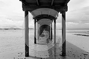 Bridge over the sea during ebb tide in black and white